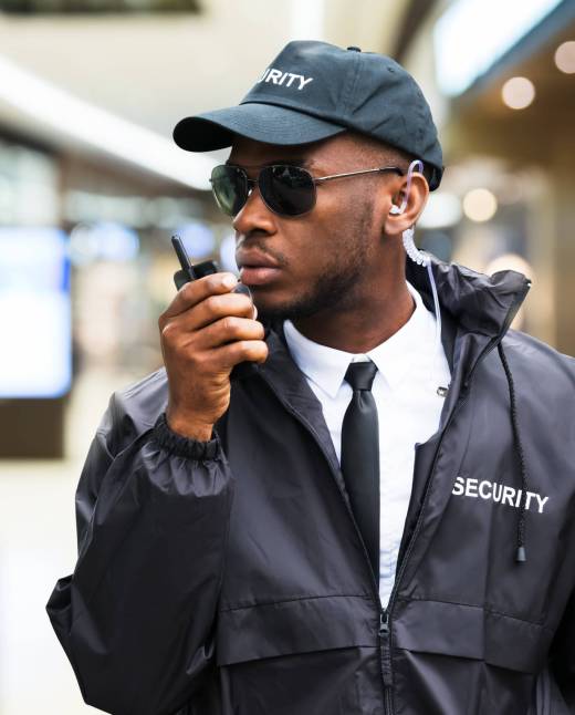 Security Guard Using Walkie Talkie In Shopping Mall